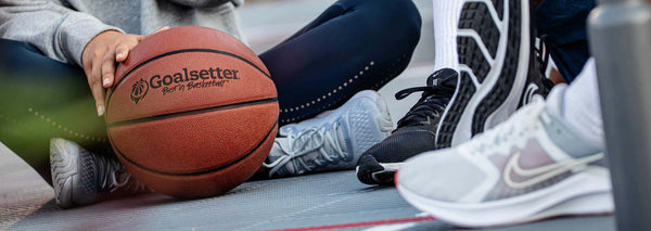 athletes resting with a basketball on a court